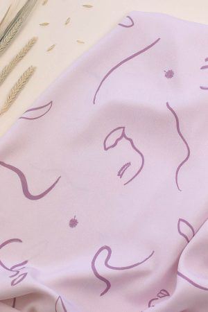 Tejido de viscosa de fondo malva con motivos de caras pictóricas, hojas y líneas simulando el viento en color malva oscuro