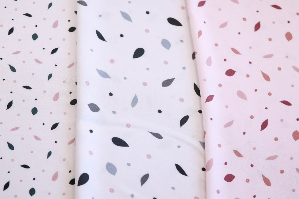 Tres retales de tela estampados con motivos de hojas en diferentes colores y tamaños.