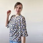 Mujer de pelo castaño luce una hermosa blusa Mille Friori con estampados en tonos pastel y azul.