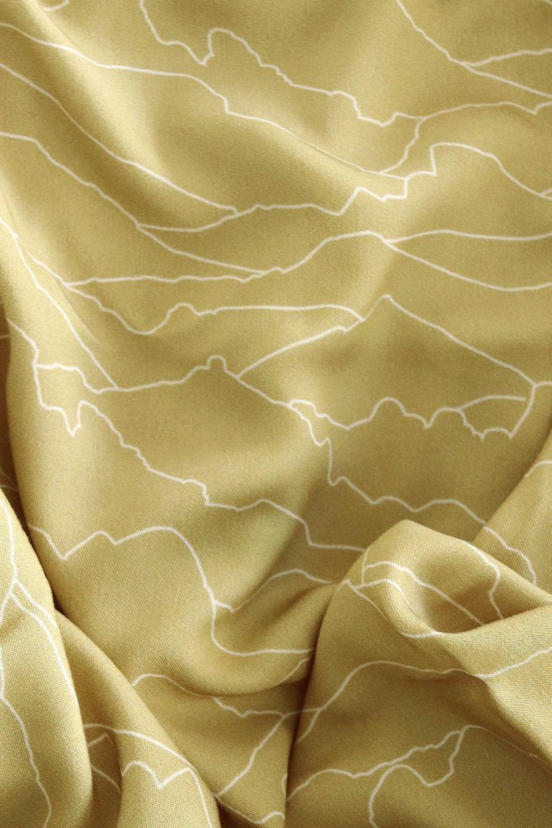 Horizonte gold Tela color golden (oro, pastel) con patrones que evocan el horizonte en líneas blancas.
