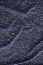 Tela azul oscuro en la que aparecen líneas en color blanco entrelazadas entre sí. Estas líneas son el contorno de diferentes montañas de la geografía española, como el Monte Oroel, Naranjo de Bulmes, Pedraforca, peñas de Islallana, peñas de Aya, el Teide, pico del lobo, sierra de la Tramuntana con el pico Puig Major, Veleta, entre otros.