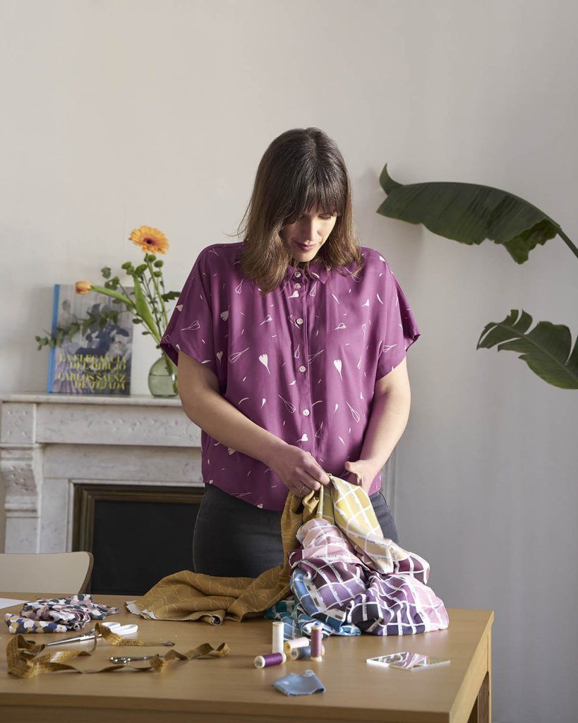 Lucía, costurera y diseñadora de ODALOA trabajando telas de diferentes colores.