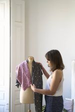 Lucía, diseñadora de ODALOA, realiza pruebas de diseño de textiles sobre busto de costura, luciendo hermosa tela de colores pasteles claros con patrones de lunares y líneas que imitan pequeñas ramas con muchas hojas.
