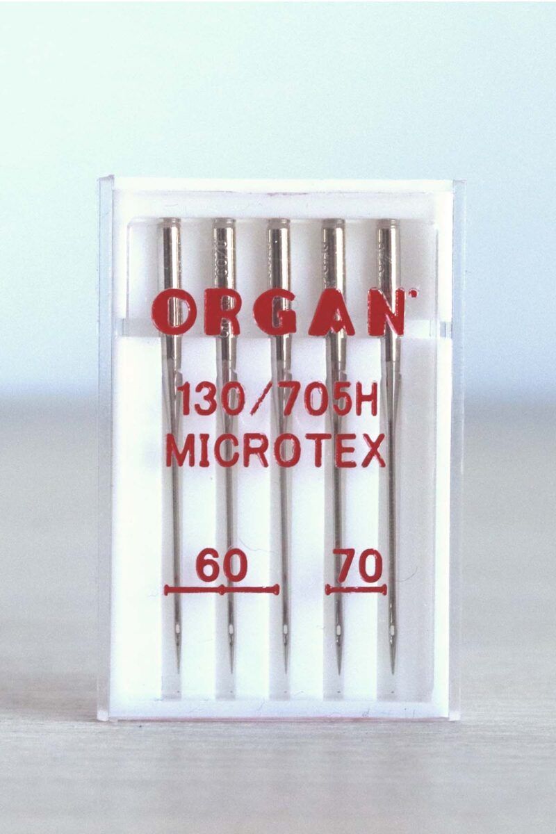 Cajita blanca con surtido de 5 agujas de coser a máquina. En la caja se puede leer en rojo la marca, ORGAN, el tipo de aguja (Microtex) y los grosores de la aguja: 60 y 70.