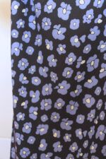 Salvaje azul Tela de fondo negro con flores que imitan las manchas de leopardo en color azul y centro color mantequilla