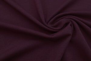 Plano cerca de la textura de una tela de punto camiseta de algodón en color mora