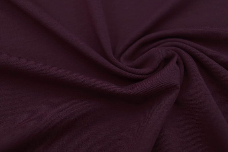 Plano cerca de la textura de una tela de punto camiseta de algodón en color mora