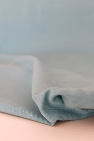 Plano cercano de la textura de una tela de punto jersey de algodón orgánico en color aguamarina.