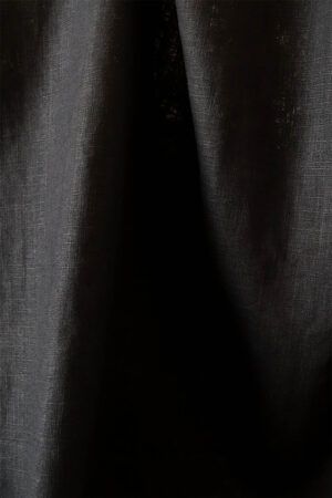 Tela de ramio en color negro. Con un aspecto como el lino. El tejido hace un par de pliegues verticales