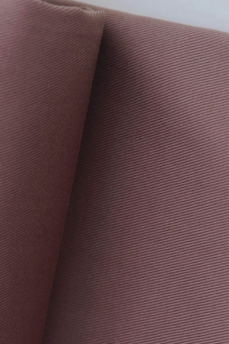 Plano detalle del entremado de sarga de una tela de gabardina rosa