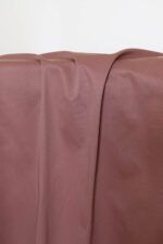 Tela de gabardina rosa antiguo Tela de gabardina de color rosa terracota que cuelga y hace unos pliegues