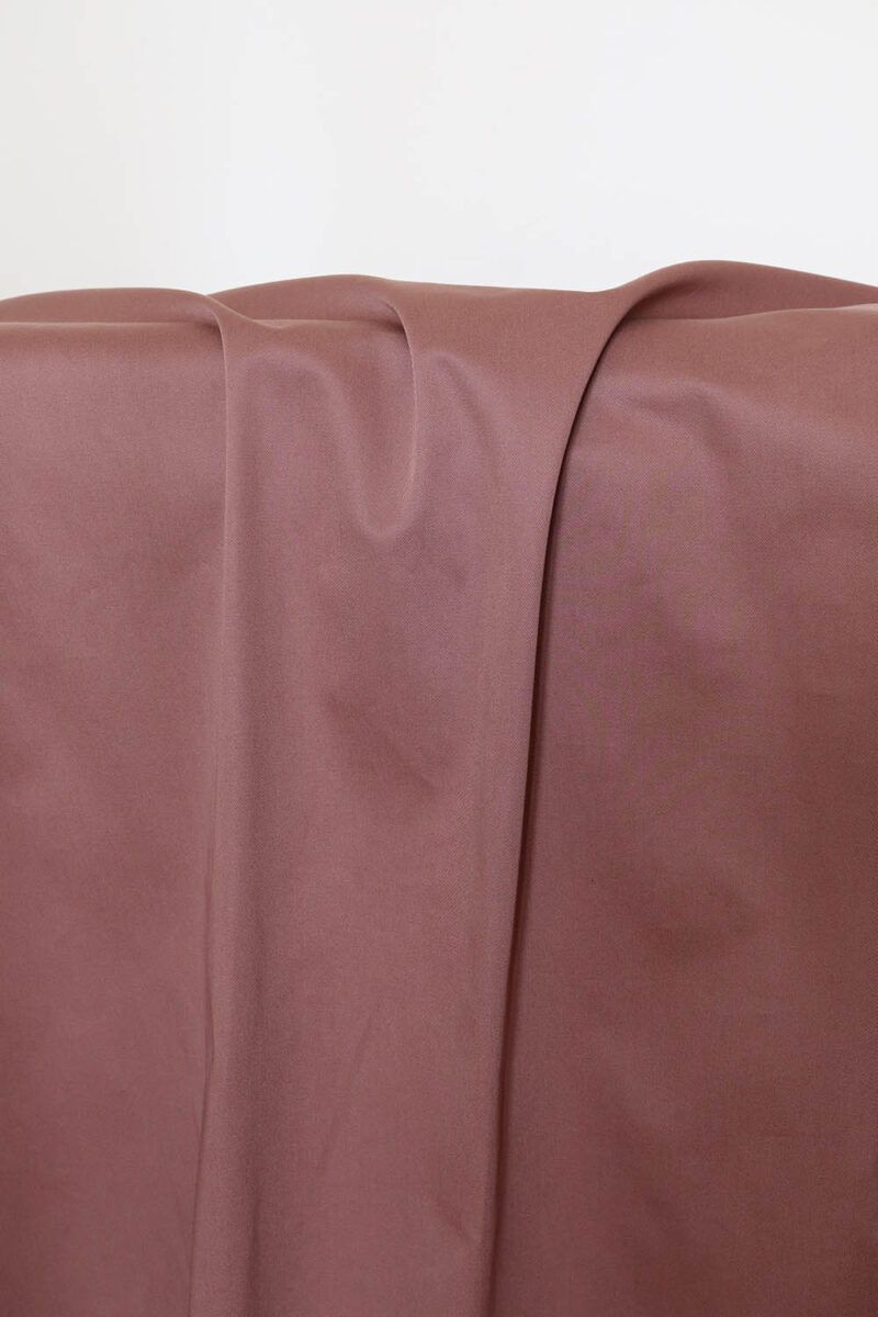 Tela de gabardina rosa antiguo Tela de gabardina de color rosa terracota que cuelga y hace unos pliegues