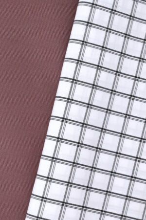 Tela blanca con rayas horizontales y verticales, de diferentes grosores, en color negro, formando cuadros. La tela se encuentra sobre otra de gabardina en color rosa.