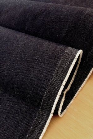 Tela vaquera en color azul muy oscuro que ondea sobre una mesa.
